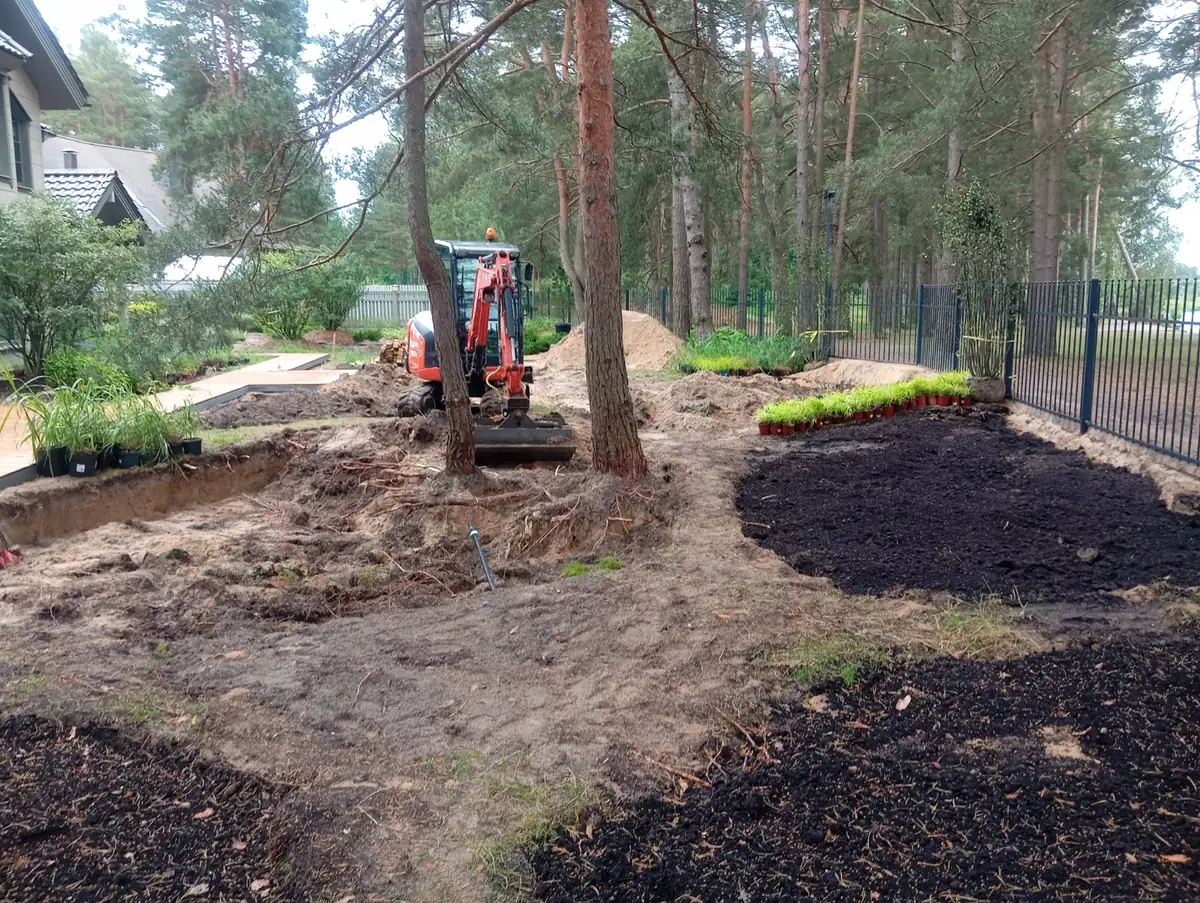 Mini ekskavators starp priedēm: zemes darbi, svaiga augsne un stādīšanai sagatavotie augi